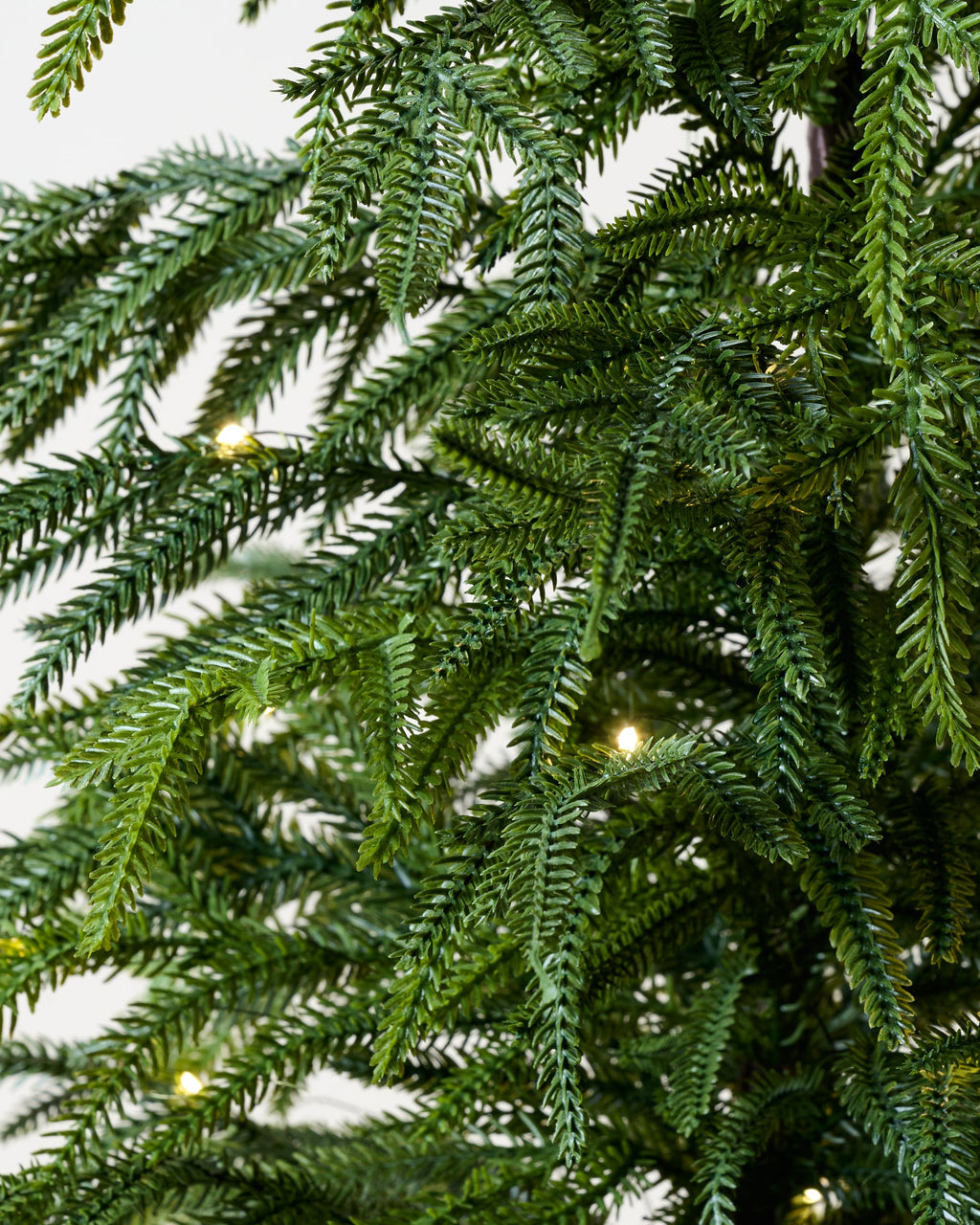 Mavelle Real Touch Norfolk Pine Pre-Lit Potted Tree faux floral stem - Close-Up